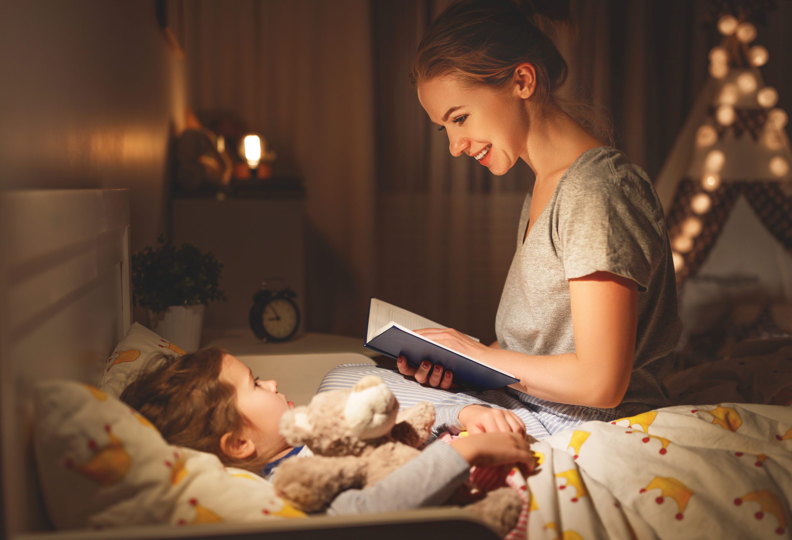 Мама и отец в кровати. Мама читает сказку ребенку. Чтение на ночь детям. Ксама уклдывает малышатспать. Мама читает книгу ребенку.